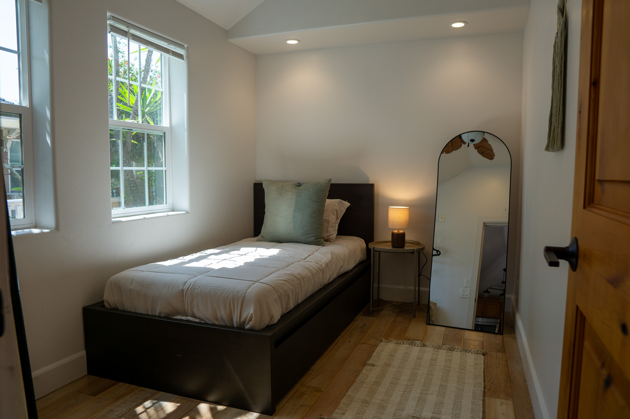 Spacious bedroom setup with clean linens and modern coastal decor for sober living.