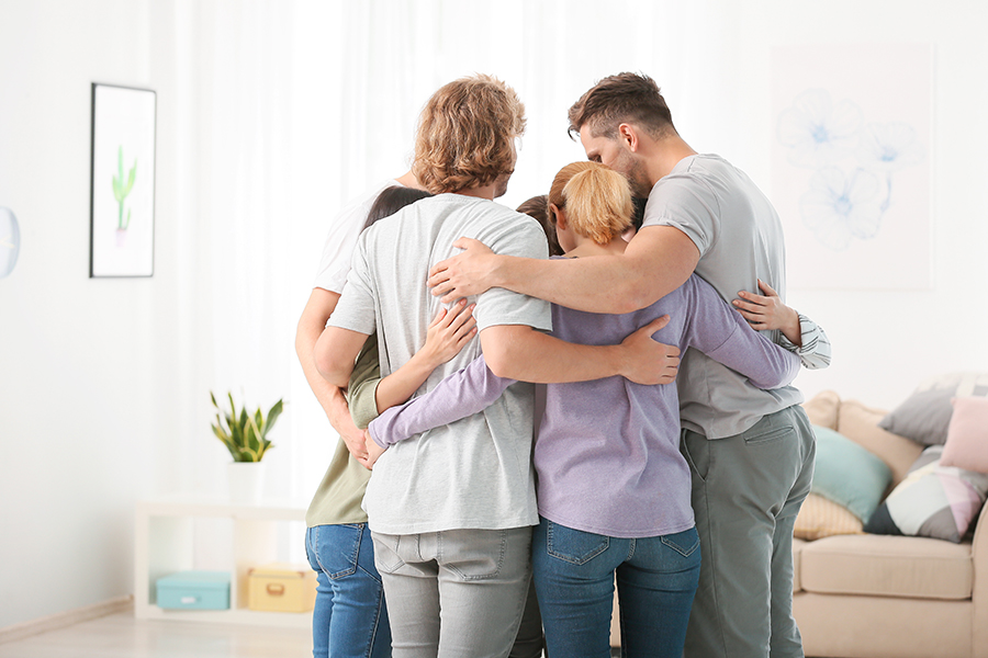 Family and friends hug symbolizing a successful drug intervention Family and friends hug symbolizing a successful drug intervention
