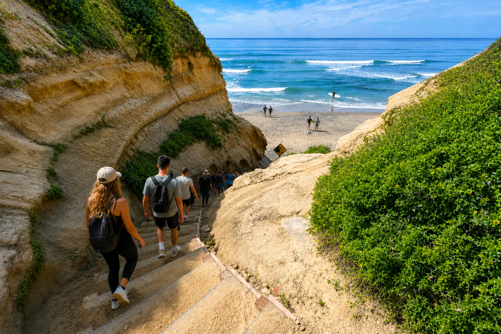 People walking down stairs to a beach in Carlsbad, CA